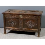 A 17th Century panelled oak coffer with two fielded panelled lid, the front carved with arcaded