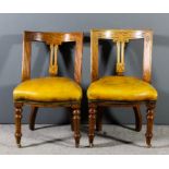 A pair of Victorian mahogany framed dining chairs, the curved crest rails, uprights and fretted