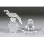 A Lalique glass ashtray, the centre modelled with a standing bird, 2.5ins high, and a Nina Ricci "