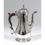 A George III plain silver baluster shaped coffee pot, the moulded and domed cover with turned finial