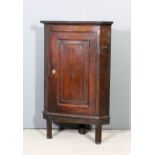 An 18th Century oak hanging corner cupboard with reeded edge to top, fitted two shaped shelves