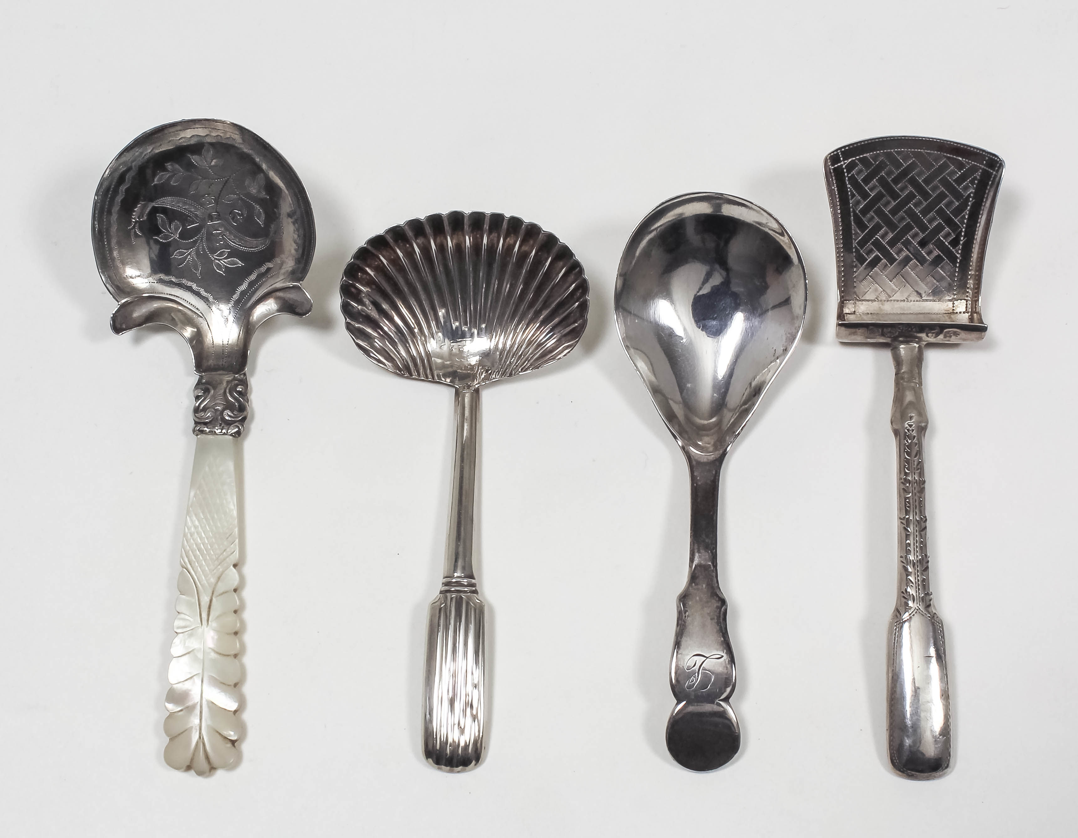 A George IV silver caddy spoon, the shaped bowl engraved with floral ornament and with carved mother