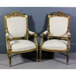 A pair of gilt framed open arm fauteuil of Louis XVI design, the shaped crest rails carved with bold