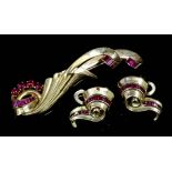 A 1950s gold coloured metal mounted ruby set brooch of scrolling form, the face set with four