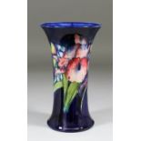 A Moorcroft pot waisted vase, tube lined and decorated in colours with an "Orchid" design on a