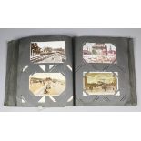 An early 20th Century postcard album containing a mixed selection of postcards, including - Black