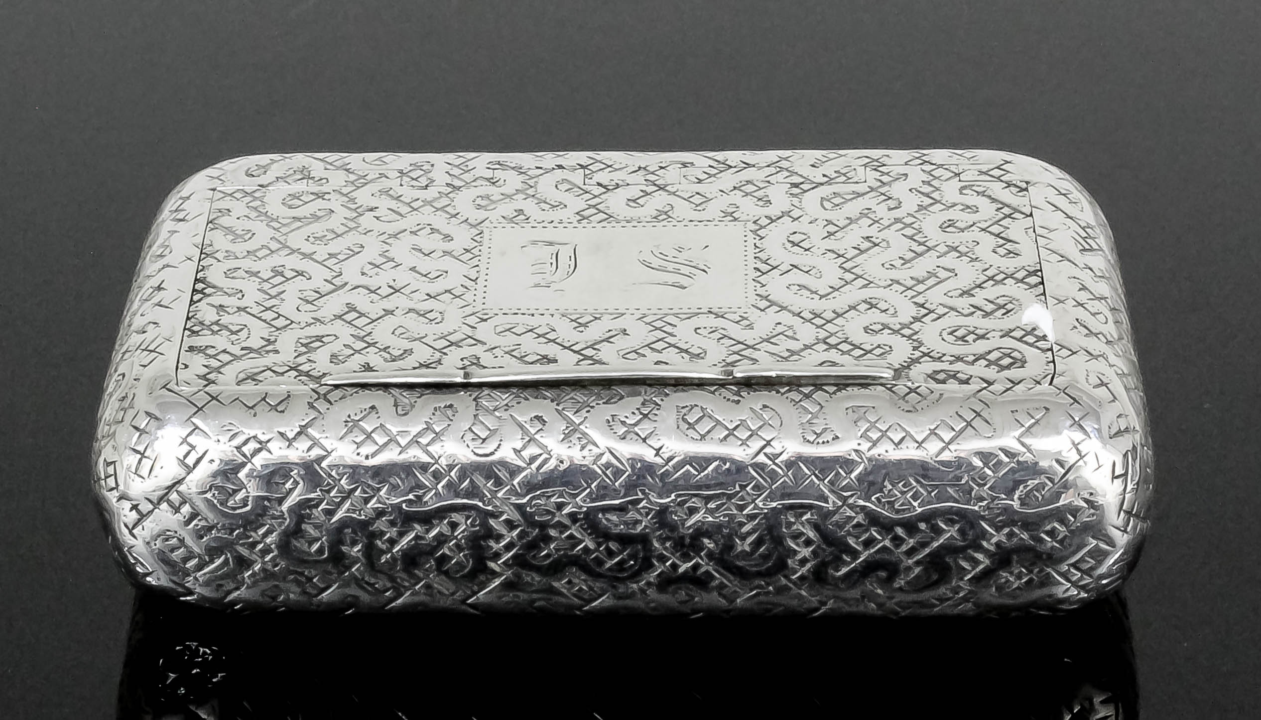 A George IV silver rectangular snuff box with curved sides, the whole engraved with scroll design on