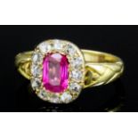 A modern 18ct gold mounted ruby and diamond ring, the cushion cut ruby approximately .85ct within