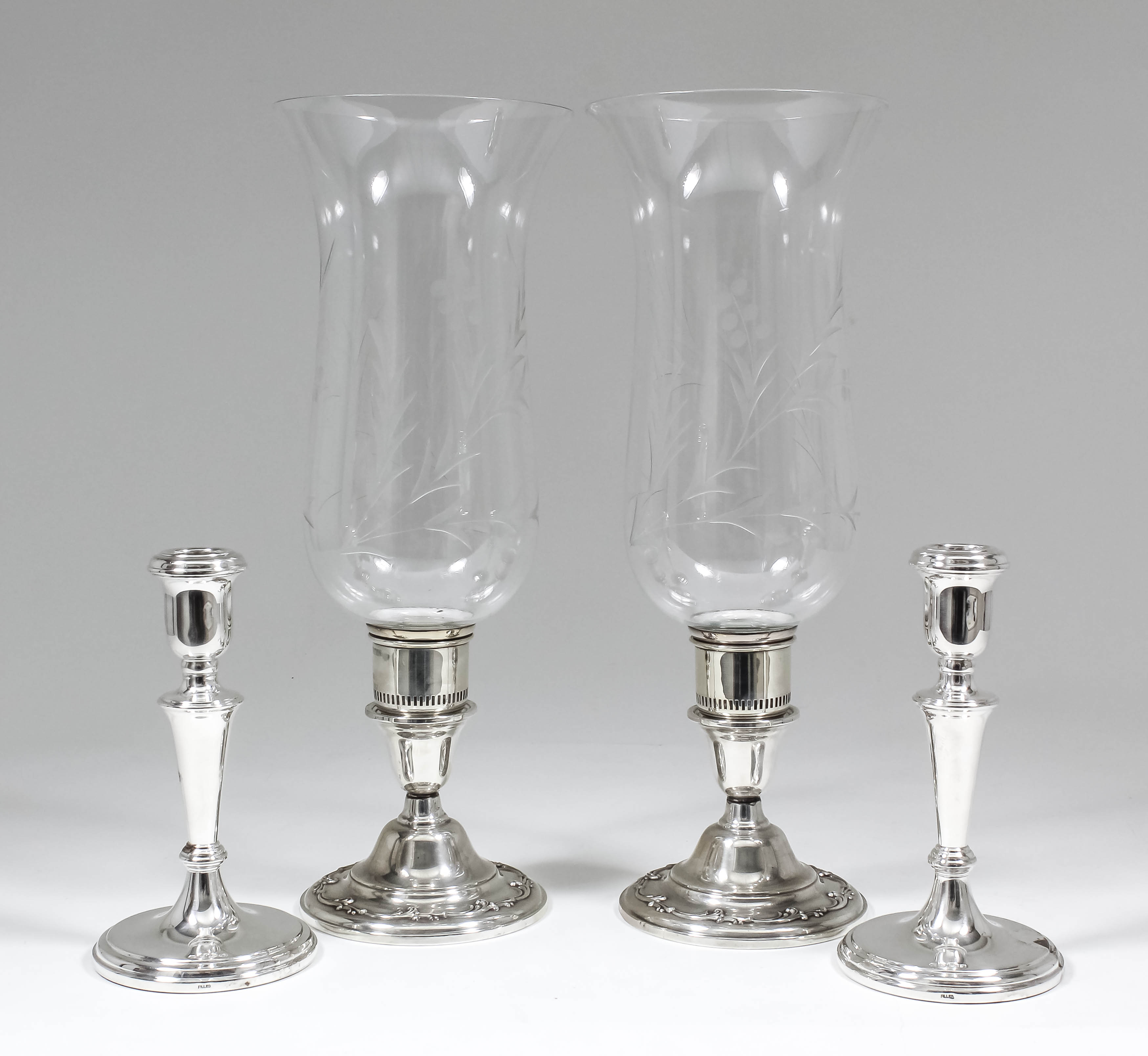 A pair of Elizabeth II silver pillar candlesticks with plain urn pattern sconces and tapered