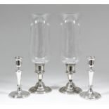 A pair of Elizabeth II silver pillar candlesticks with plain urn pattern sconces and tapered