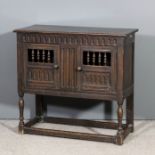 A panelled dark oak food cupboard of "17th Century" design with plain top enclosed by a pair of