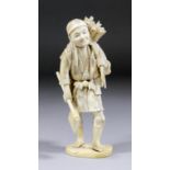 An early 20th Century Japanese carved ivory okimono of a woodcutter, 7.25ins (184mm) high (Meiji