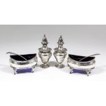 A pair of George III oval salts with slightly bulbous sides and reeded mounts, each on four scroll