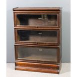 A Globe Wernicke oak three tier sectional bookcase, each tier enclosed by a rising glazed panel, and