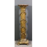 A gilt circular pedestal torchere on oval reeded column encrusted with floral ornament, on square