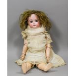 A Simon & Halbig (K&R) bisque headed doll with closing blue eyes and open mouth showing four