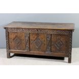 A 17th Century panelled oak coffer with moulded edge to top, the front carved with scroll ornament