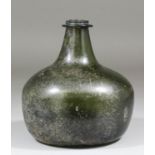 A 17th Century dark green glass squat onion shaped wine bottle with flanged string rim and cone