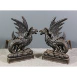 A pair of Victorian cast iron andirons cast in the form of seated griffins on plinth bases, 30ins