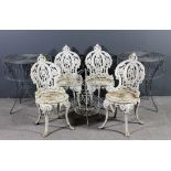 A set of four 19th Century French white painted cast iron garden chairs with ornate shaped backs and