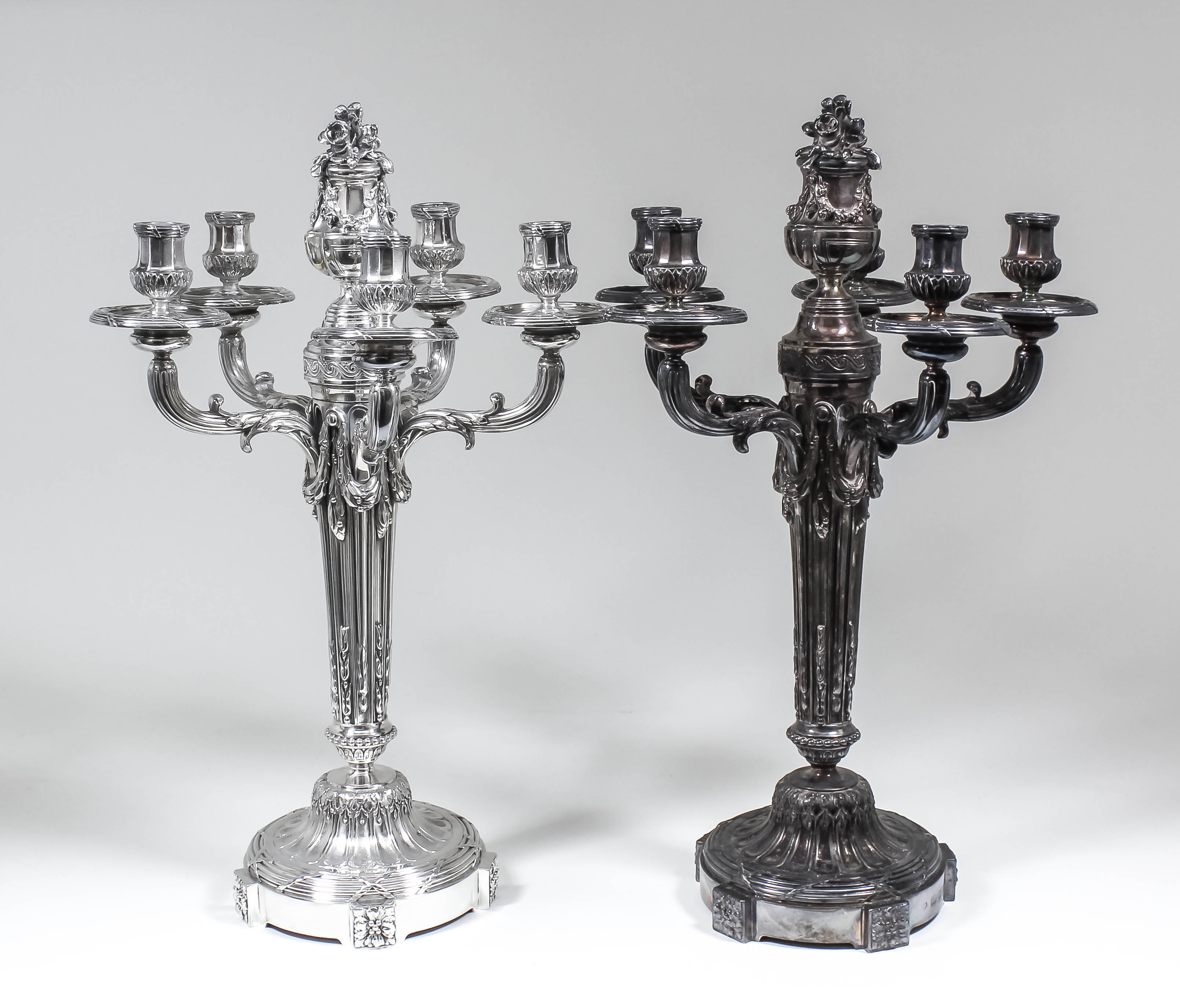 A pair of George V silver five light candelabra of Louis XVI design, the centre column surmounted by