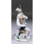 A modern Lladro porcelain figure of "Don Quixote" seated on a rocky stump and holding a sword,