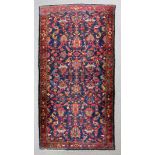 A Malayer carpet woven in colours with numerous floral filled palmettes and trailing leaf ornament