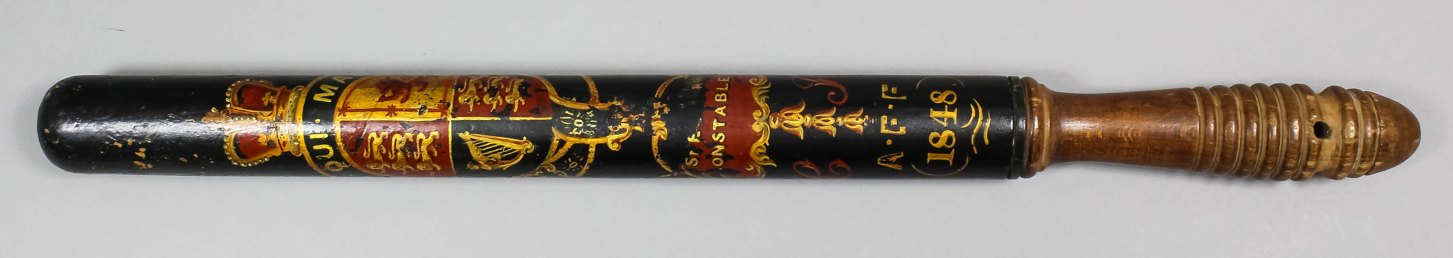 An early Victorian turned wood truncheon painted with the royal arms within a garter above "