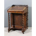 A Victorian rosewood Davenport with shaped and carved top, leather lined slope enclosing two real