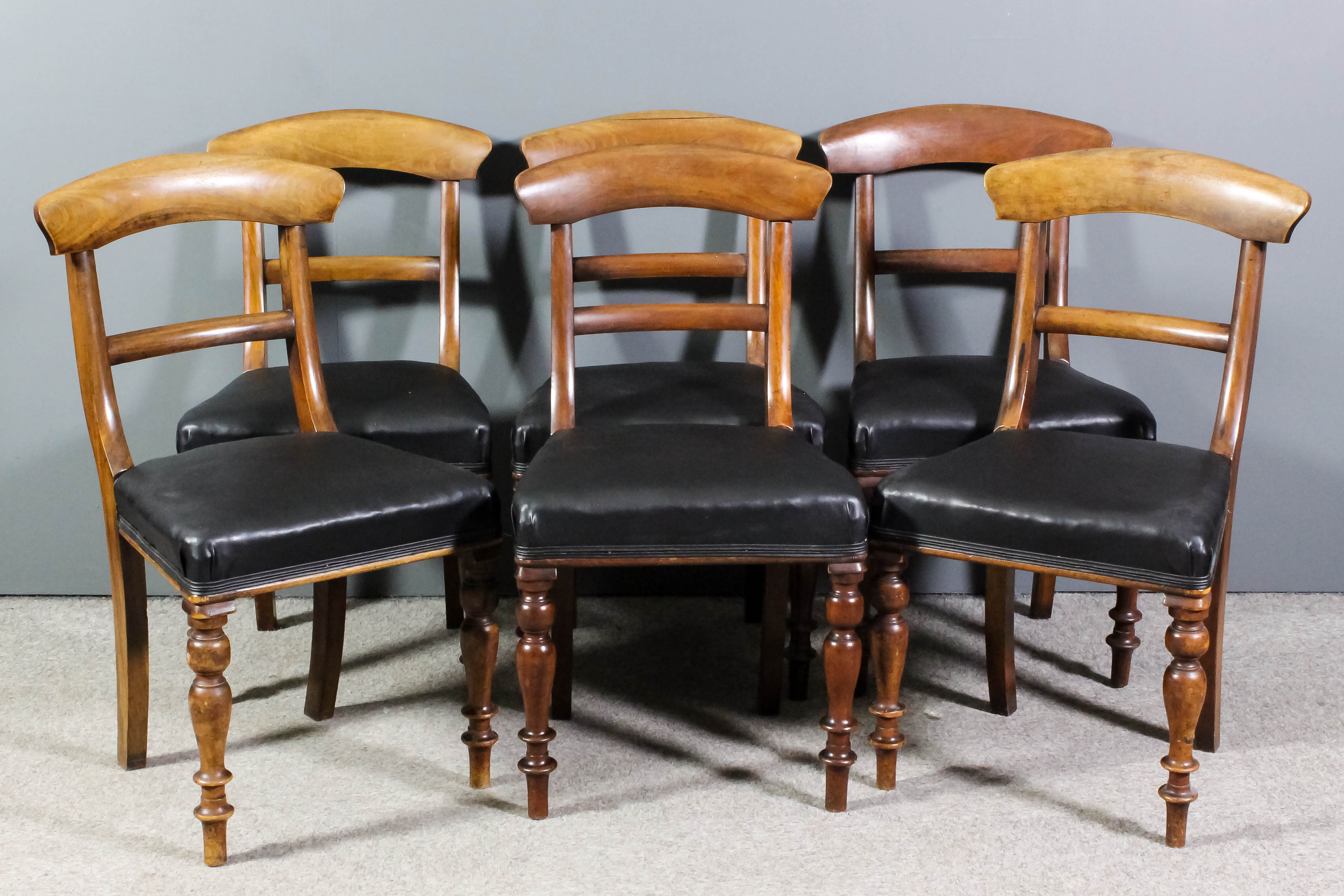 A set of six Victorian mahogany dining chairs with deep curved crest rails and plain splats, the
