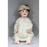 A late 19th/ early 20th Century German bisque headed baby doll, with closing blue glass eyes and