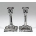 A pair of Edward VII silver pillar candlesticks with oval bead mounts, leaf cast capitols and reeded