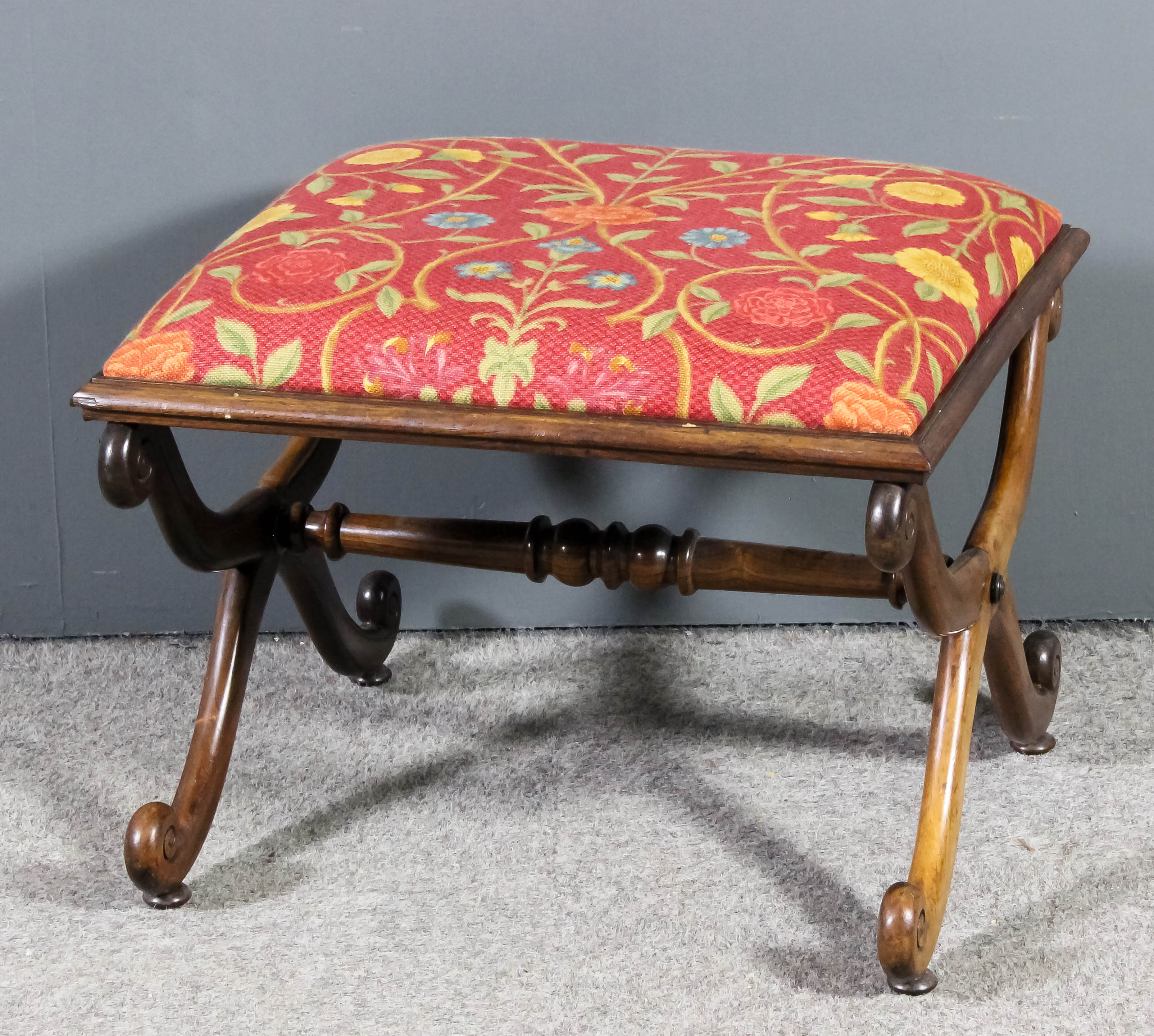 A William IV rosewood framed rectangular stool, the seat upholstered in red floral cloth, on X-