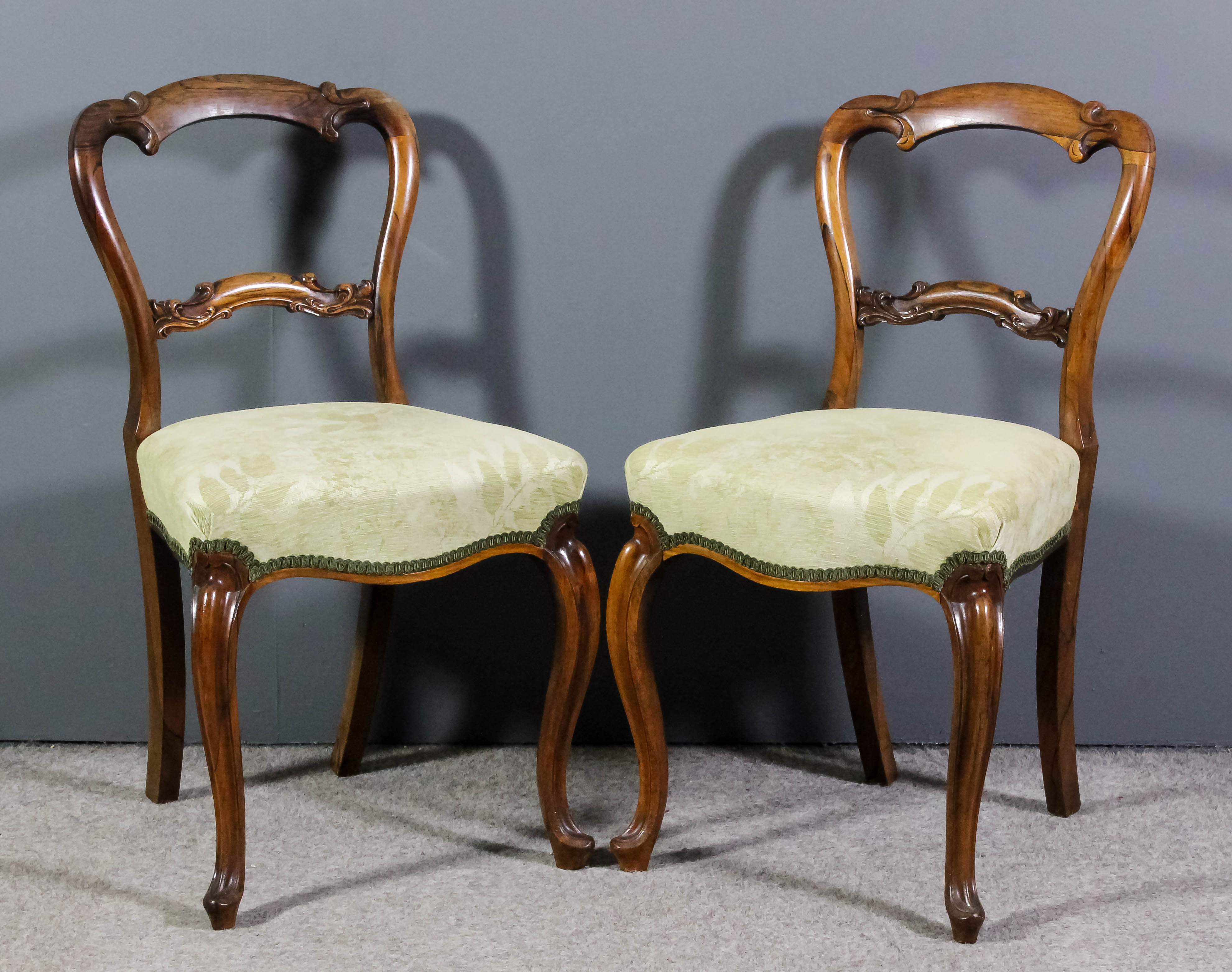 A pair of Victorian rosewood occasional chairs, the shaped backs with scroll carved crest rails