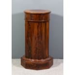 An early Victorian mahogany cylindrical pedestal cupboard with plain top and fluted sides, fitted