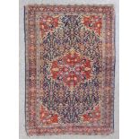 An Eastern rug of Persian design woven in dark colours with a bold styl floral filled central