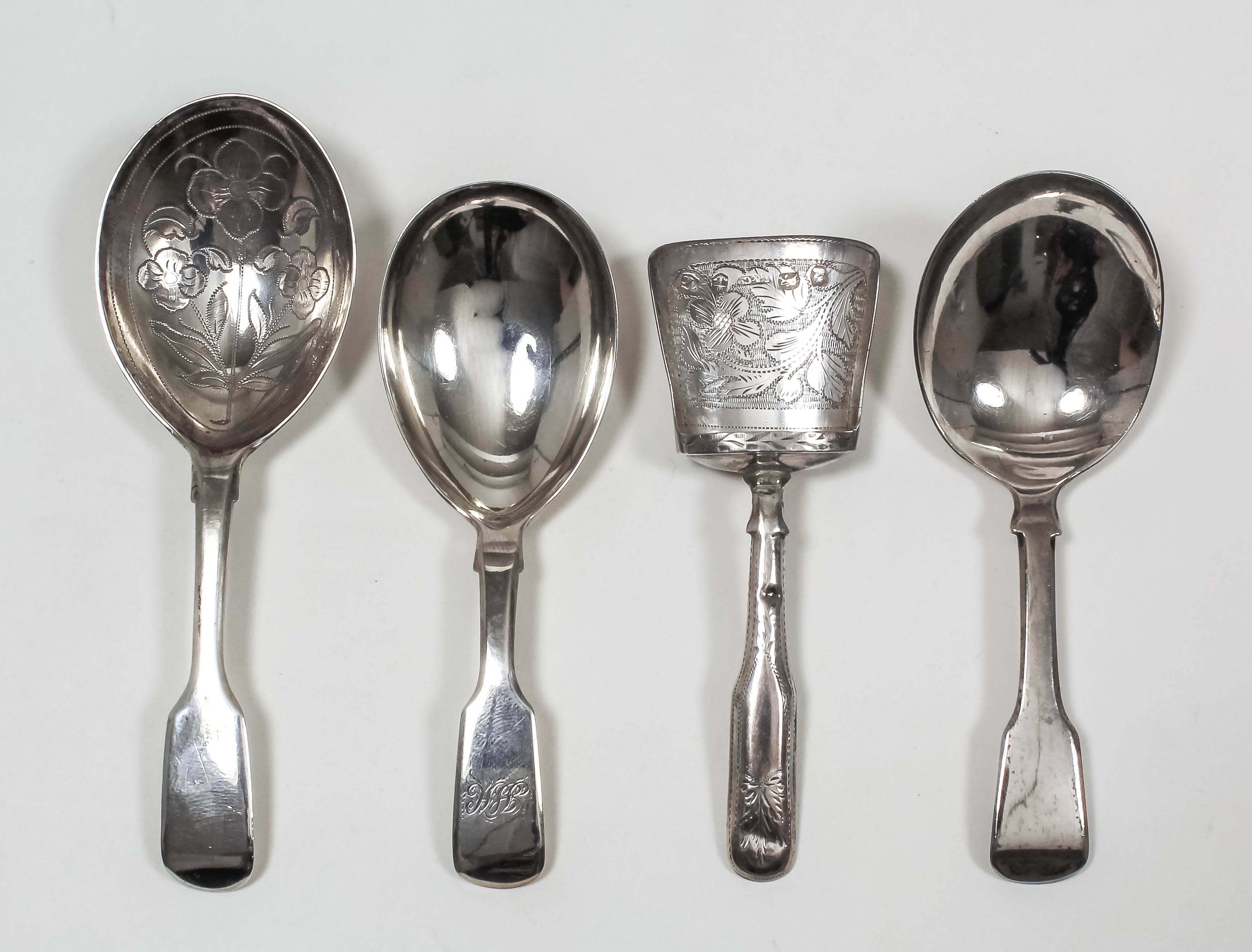 Three George IV silver caddy spoons - with oval bowl with wrigglework in the form of flowers and