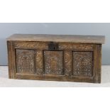 A late 17th/early 18th Century panelled oak coffer with plain top, the front carved with leaf scroll