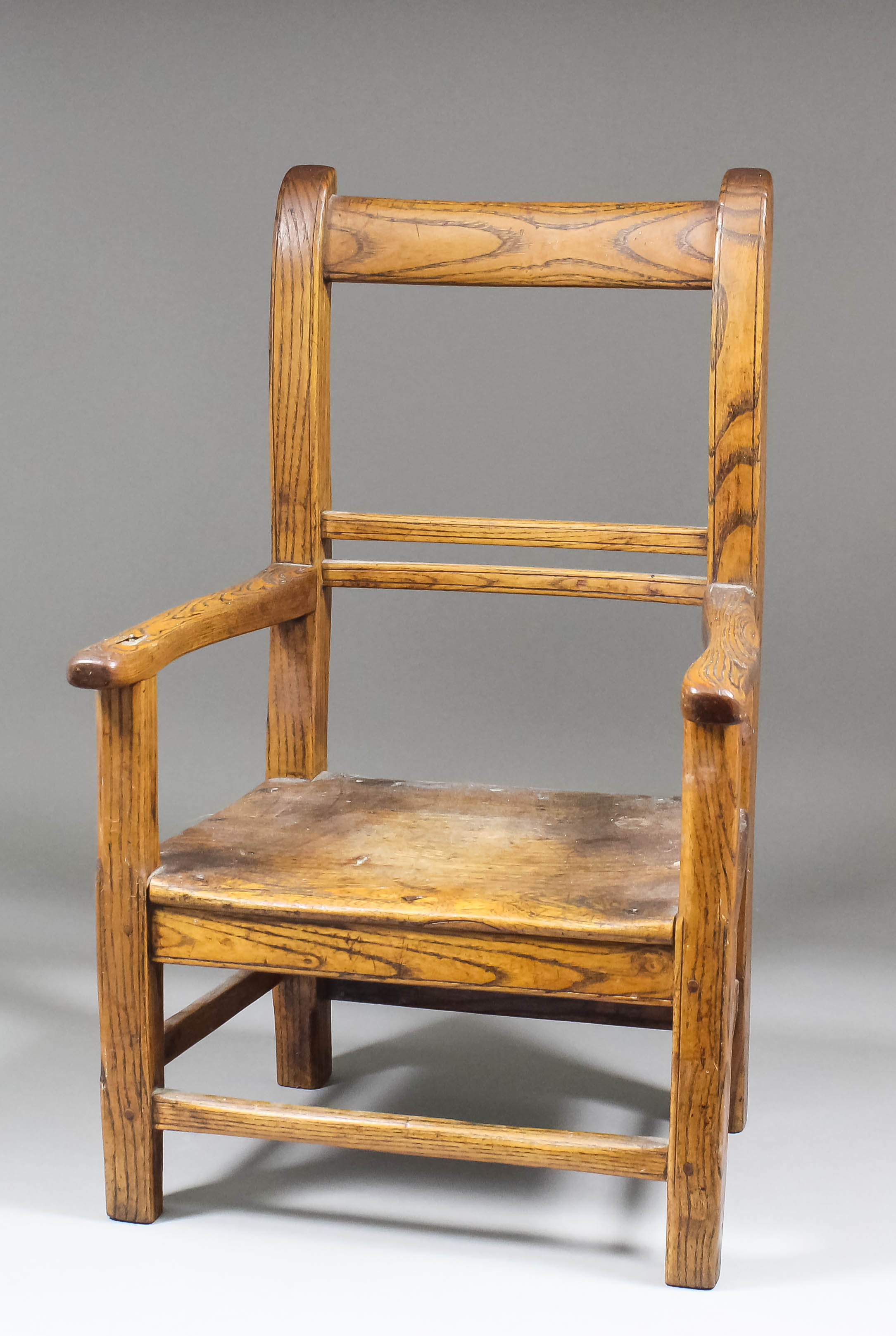 A 19th Century child's ash and elm armchair with plain top rail and of pegged construction, 19.