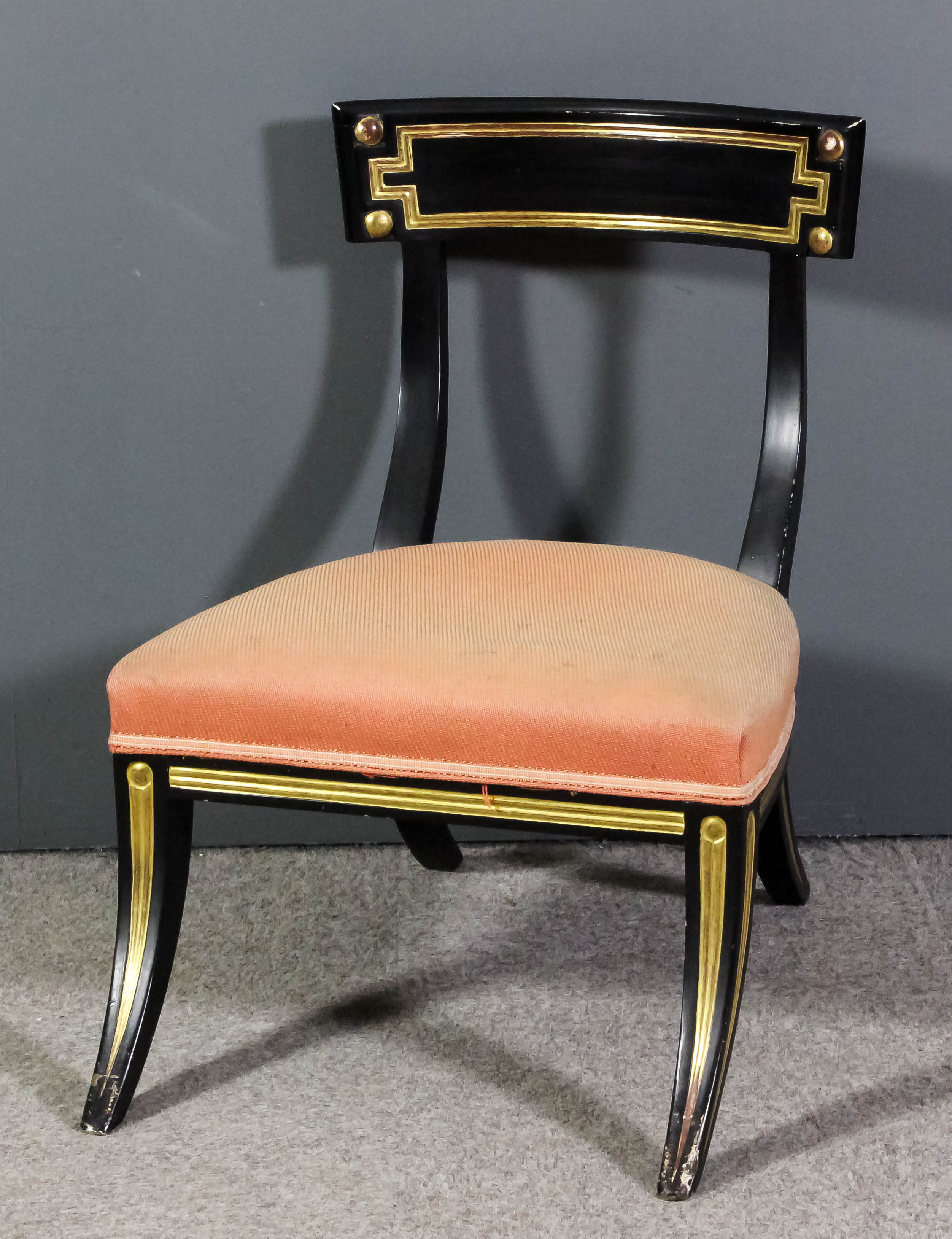 A 19th Century ebonised and parcel gilt "Klismos" nursing chair with deep curved crest rail, the