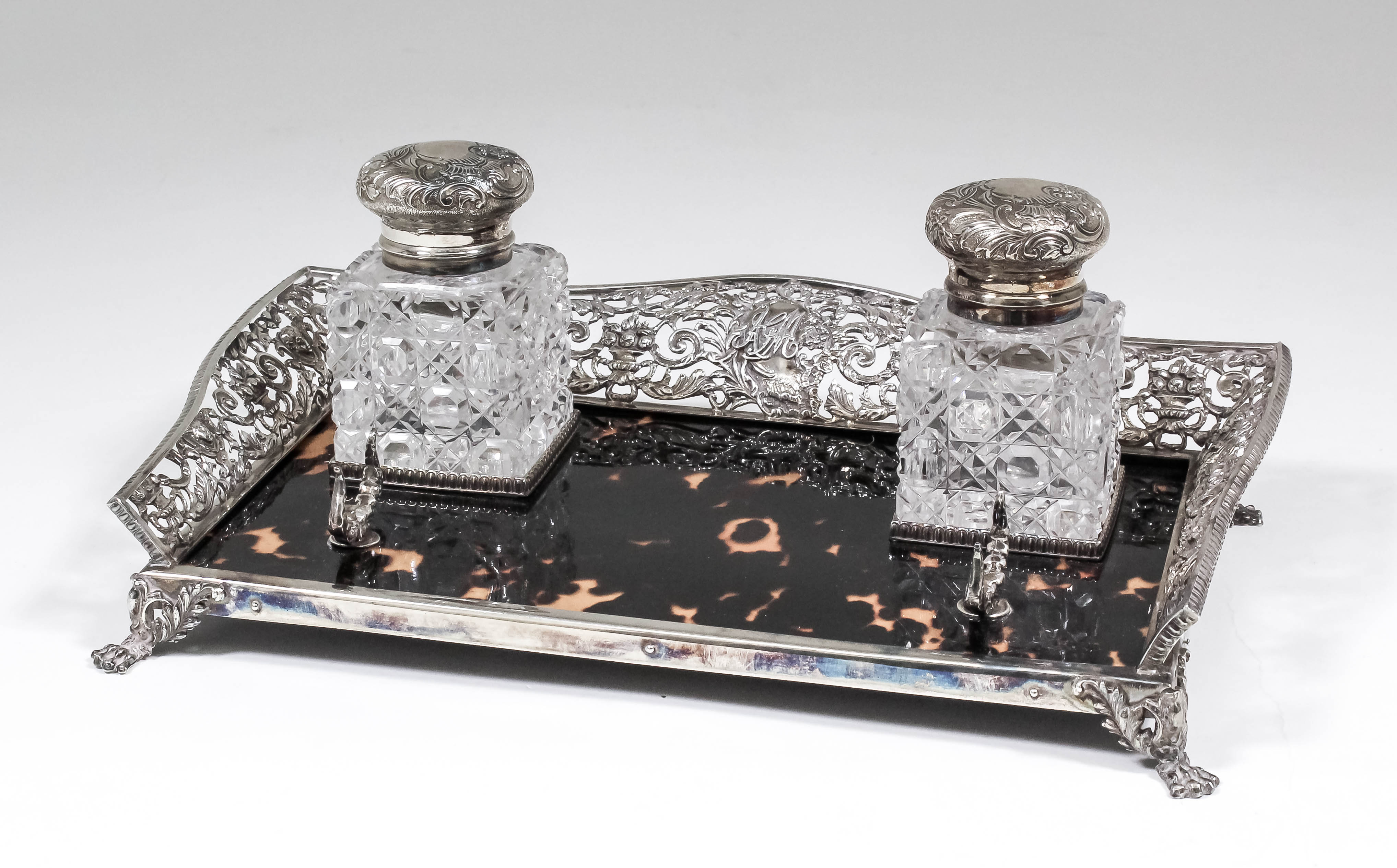 A late Victorian silver and tortoise-shell rectangular inkstand, the shaped rim pierced and cast