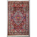 A Bakhtiar rug woven in colours with a bold central floral filled medallion and conforming