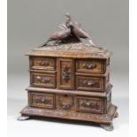 A 19th Century "Black Forest" carved wood jewellery cabinet, carved with swags of flowers,