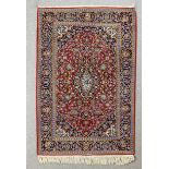 A modern European rug of Persian design woven in colours with a central floral and leaf filled