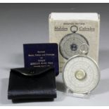 A Halden Calculex circular slide rule, 2.375ins diameter, in leather case and complete with rules,