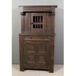 An old panelled oak court cupboard of "17th Century" design, the upper part with overhanging top