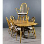 An Ercol elm rectangular extending dining table with two extra leaves, on square tapered and splayed