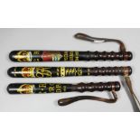 A George V turned wood truncheon painted with a crown over the royal cipher above arms bearing three