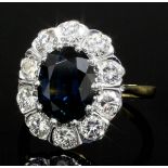 An 18ct gold mounted sapphire and diamond oval cluster ring, the central sapphire approximately