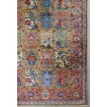 A Tabriz carpet woven in colours with seven rows each of eight rectangular tiles decorated with urns